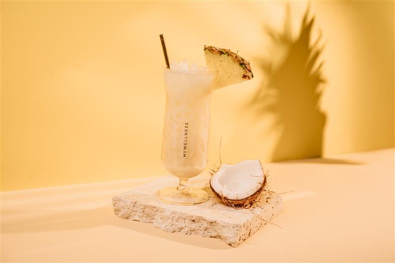 Schön hergerichteter Cocktail mit einer Scheibe Ananas und einer halben Kokosnuss
