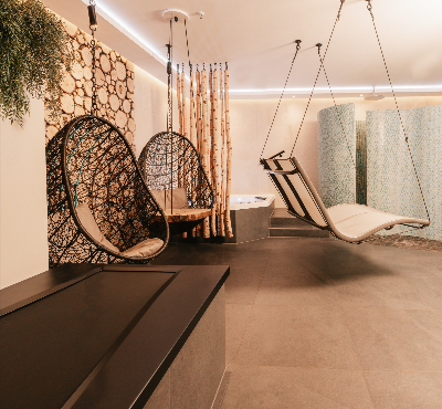 Darstellung einer Suite mit Massageliege, Whirlpool und Hängesesseln