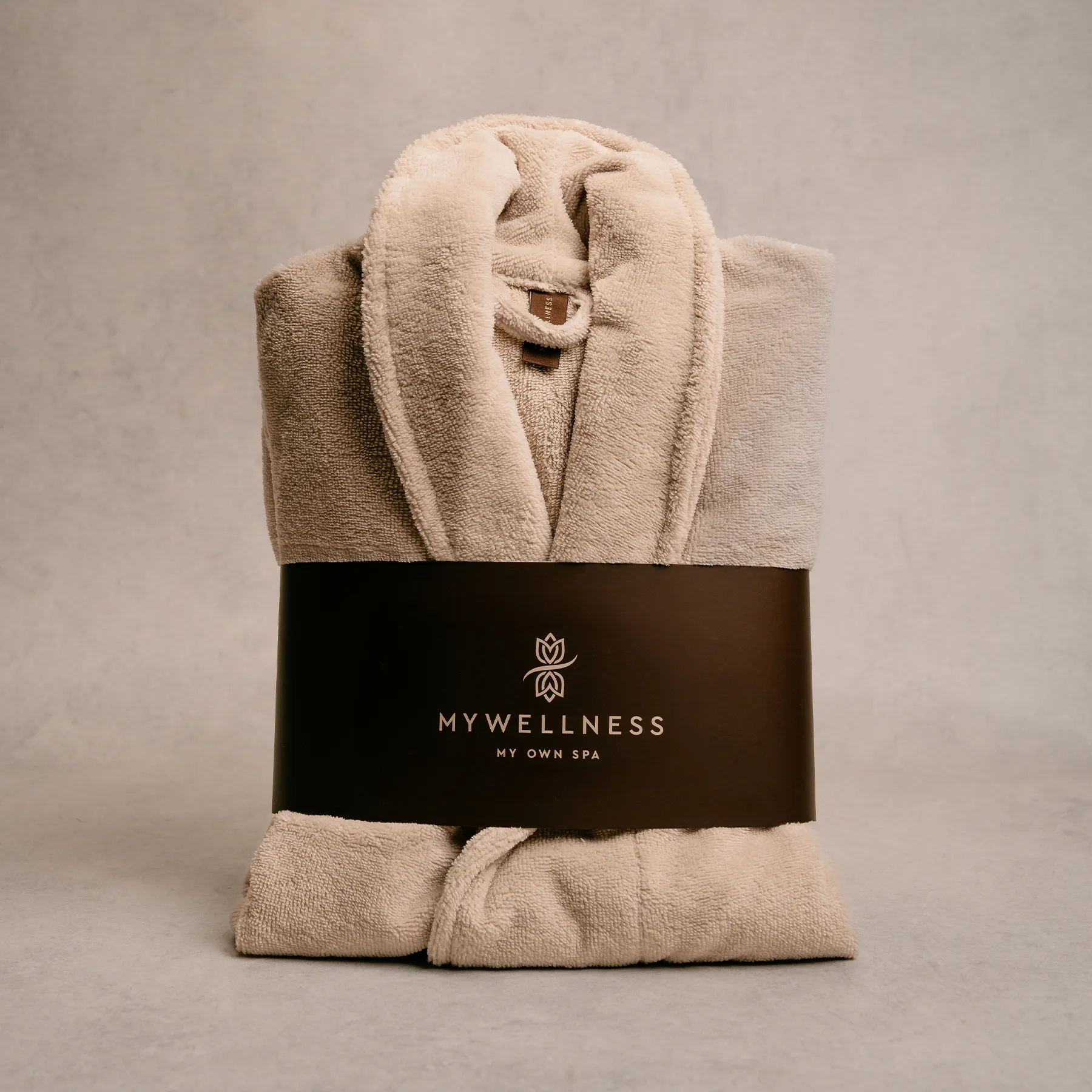 Gefalteter MyWellness Bademantel in Beige mit schwarzer Verpackungsbanderole