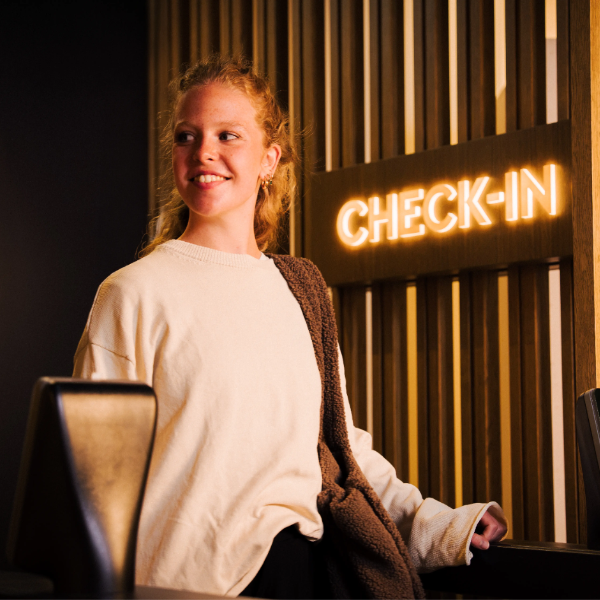 Gast beim Check-in am beleuchteten MyWellness Empfangsbereich