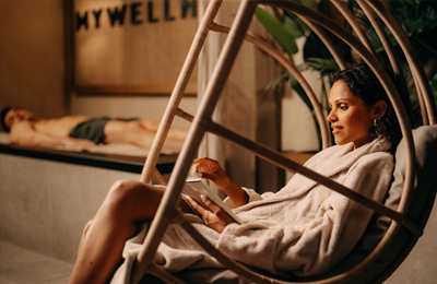 Frau im Bademantel entspannt im Hängesessel der MyWellness Suite