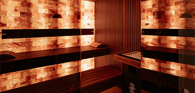 Salzsteinsauna mit Holzbänken und warmem Licht im MyWellness Mannheim