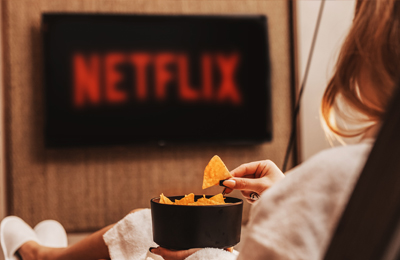 Frau im Bademantel schaut Netflix auf dem Suite-TV bei MyWellness