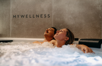 Pärchen entspannt mit geschlossenen Augen im Whirlpool der MyWellness Suite